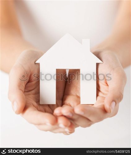 closeup pisture of woman hands holding paper house