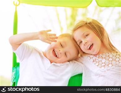 Closeup portrait adorable children having fun on swing outdoors, best friends playing on backyard in daycare, healthy and happy lifestyle, strong friendship concept