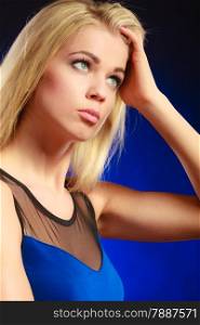 Closeup portrait attractive thoughtful woman, blonde long hair girl looking up dreaming dark blue background