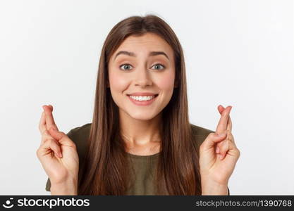 Closeup portrait hopeful beautiful woman crossing her fingers, open eyes, hoping, asking best isolated on gray wall background. Closeup portrait hopeful beautiful woman crossing her fingers, open eyes, hoping, asking best isolated on gray wall background.