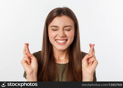 Closeup portrait hopeful beautiful woman crossing her fingers, open eyes, hoping, asking best isolated on gray wall background. Closeup portrait hopeful beautiful woman crossing her fingers, open eyes, hoping, asking best isolated on gray wall background.