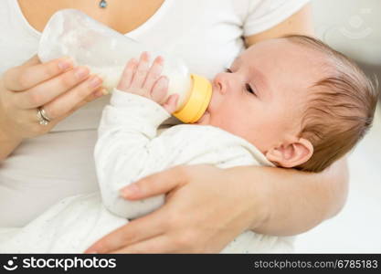 Closeup portrait of 3 months old baby eating milk from bottle