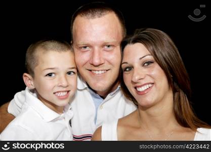 Closeup portrait of a beautiful father, mother, and son on black background.
