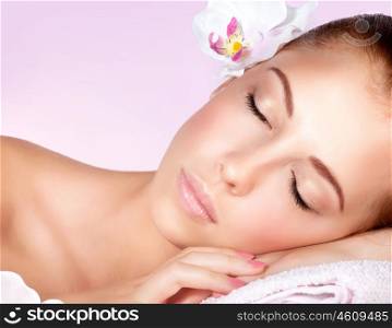 Closeup portrait of a beautiful gentle woman with closed eyes relaxing on massage table in spa salon, healthy lifestyle, beauty treatment