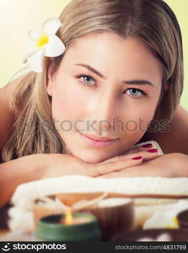 Closeup portrait of a beautiful woman at spa salon, lying down on the massage table, health care and beauty treatment