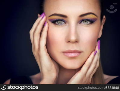 Closeup portrait of a beautiful woman face over dark background, gorgeous model with colorful stylish makeup, fashion look, luxury beauty salon