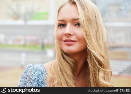 Closeup portrait of a beautiful woman in the city at summer time with modern building at the background