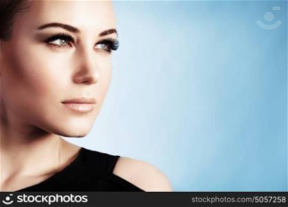 Closeup portrait of a beautiful woman isolated on blue background, gorgeous girl with perfect makeup, good looking model