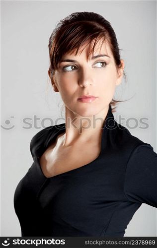 Closeup portrait of a beautiful woman with a serious expression, isolated over a gray background