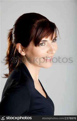 Closeup portrait of a beautiful young woman isolated over a gray background