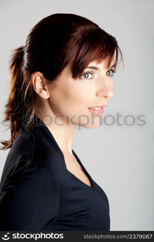 Closeup portrait of a beautiful young woman isolated over a gray background