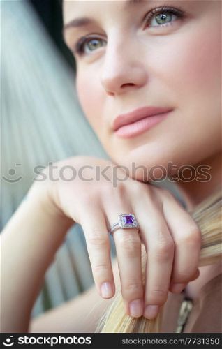 Closeup Portrait of a Beautiful Young Woman Wearing Gorgeous Stylish Ring with Blue Precious Stone. Face Part. Luxury Fashionable Jewelry.. Beautiful Woman with Ring on Finger