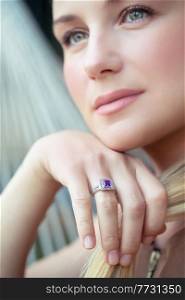 Closeup Portrait of a Beautiful Young Woman Wearing Gorgeous Stylish Ring with Blue Precious Stone. Face Part. Luxury Fashionable Jewelry.. Beautiful Woman with Ring on Finger