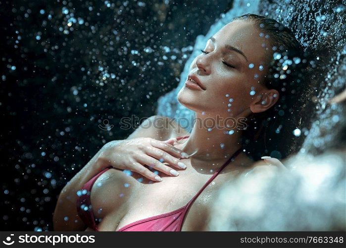 Closeup portrait of a blond lady taking a waterfall bath