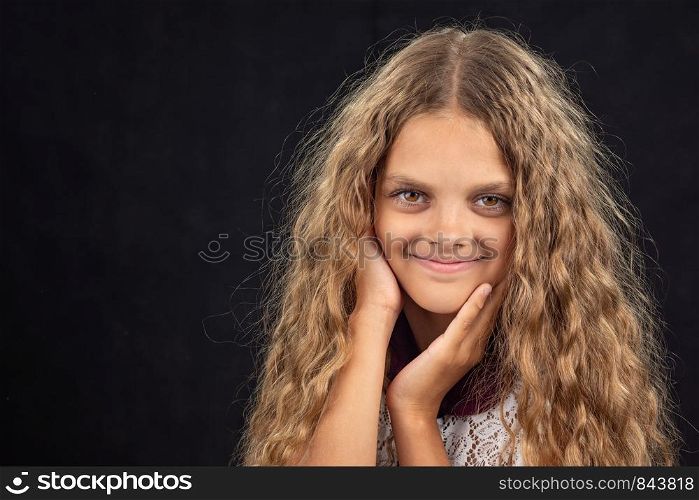 Closeup portrait of a cheerful ten year old girl on black background