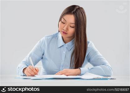 Closeup portrait of a cheerful young businesswoman doing paperwork