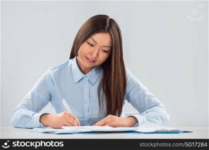 Closeup portrait of a cheerful young businesswoman with a pen in her hand