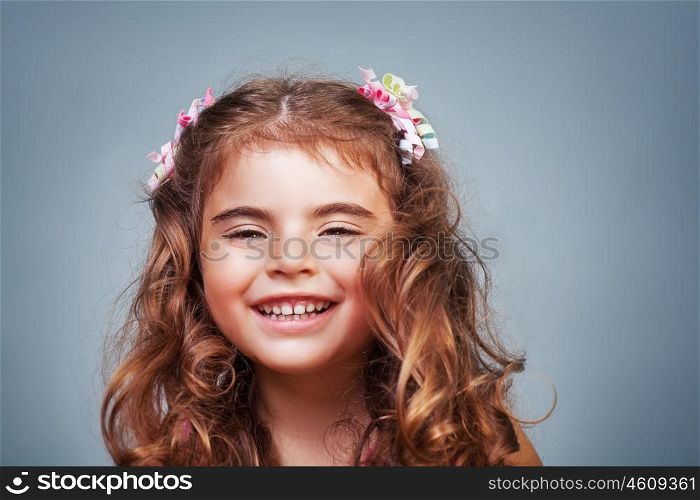 Closeup portrait of a cute cheerful little girl laughing isolated on gray background, precious baby in good mood, happy healthy childhood