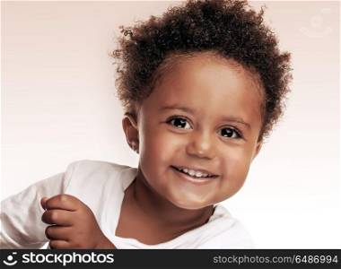 Closeup portrait of a cute little african american boy isolated on beige white background, sweet kid having fun in the studio, happiness and carefree childhood concept. Cute little boy