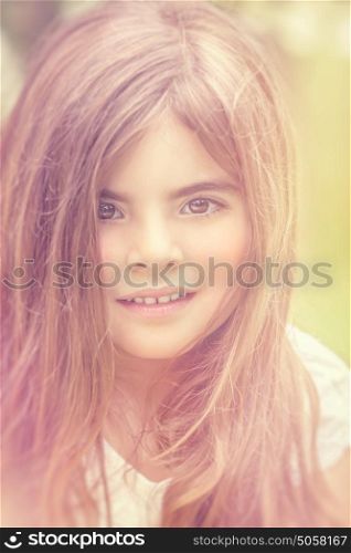 Closeup portrait of a cute little dreamy girl in mild day light outdoors, vintage style photo, genuine beauty of a child