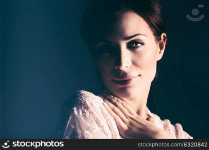 Closeup portrait of a gentle female over dark background, beautiful woman wearing nice tender lace peignoir, fashion look of bride in the morning