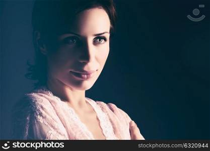Closeup portrait of a gentle female over dark background, beautiful woman wearing nice tender lace peignoir, fashion look of bride in the morning