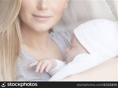 Closeup portrait of a gentle mother holding in hands her newborn sleeping baby at home, enjoying parenthood, love in the family, new life concept