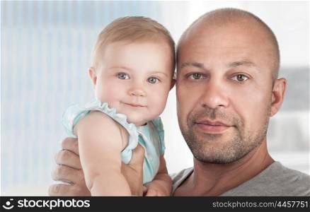 Closeup portrait of a handsome dad with cute little daughter on hands, spending time at home, happy fathers day theme&#xA;