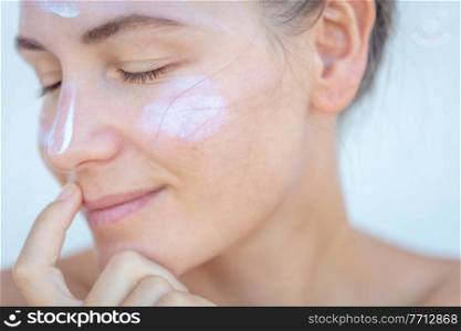 Closeup Portrait of a Nice Blond Female with Sun Cream on a Face. Closed Eyes. Using Spf Before Going to Beach. Health Care. Beauty Treatment at Spa.. Using Face Cream