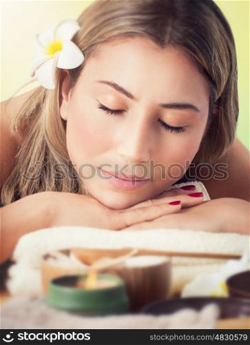 Closeup portrait of a peaceful woman with closed eyes lying down on a massage table in the spa salon, healthy lifestyle