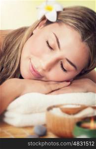 Closeup portrait of a peaceful woman with closed eyes lying down on a massage table in the spa salon, luxury healthy lifestyle