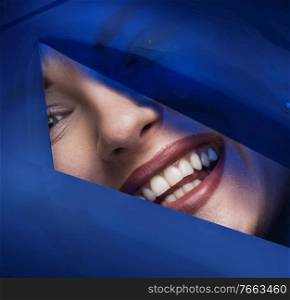 Closeup portrait of a pretty woman posing with a plastic, blue tape
