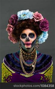 Closeup portrait of a woman with a sugar skull makeup dressed with flower crown. Halloween concept