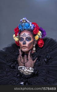 Closeup portrait of a woman with a sugar skull makeup dressed with flower crown. Halloween concept