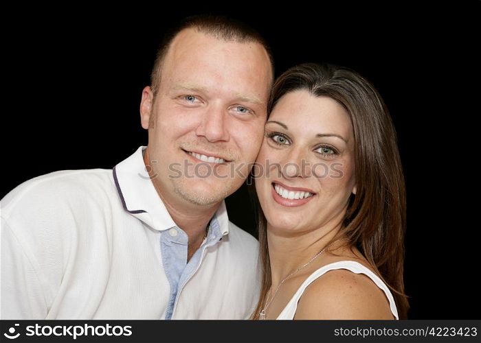 Closeup portrait of a young married couple over black background.