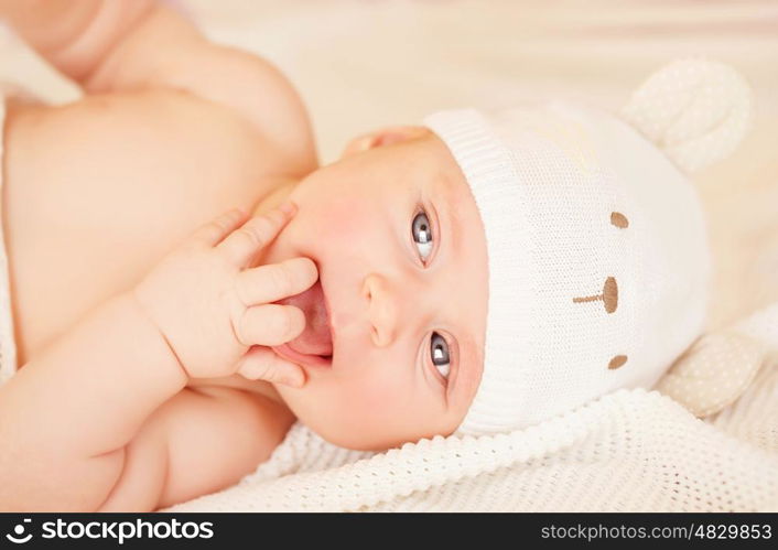 Closeup portrait of adorable newborn baby lying down in bed at home, carefree childhood, child care, innocence and purity concept