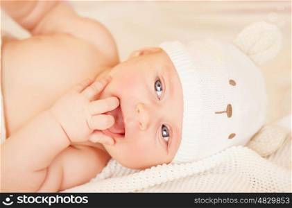 Closeup portrait of adorable newborn baby lying down in bed at home, carefree childhood, child care, innocence and purity concept