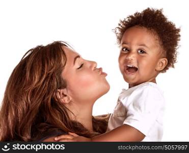 Closeup portrait of African family having fun in the studio, cheerful mother try to kiss her cute little son, happy childhood concept