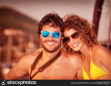 Closeup portrait of attractive young couple on the yacht in sunset light, luxury lifestyle, happy tourists on summer vacation on the sea