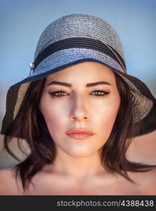 Closeup portrait of beautiful arabic woman wearing stylish sun hat, gorgeous female with perfect makeup outdoors