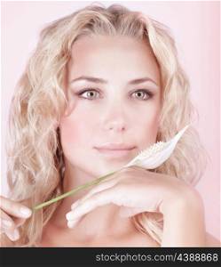 Closeup portrait of beautiful blond girl with gentle cala flower isolated on pink background, alternative medicine, luxury spa salon