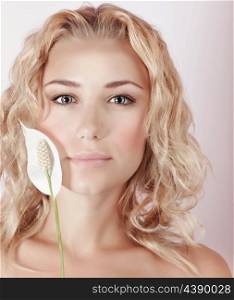 Closeup portrait of beautiful blond woman holding fresh white calla flower, natural facial cosmetics, luxury spa salon