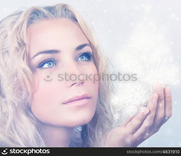 Closeup portrait of beautiful blond woman holding in hand magical glowing snowflakes, gorgeous snow queen, Christmas miracle