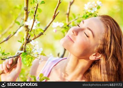 Closeup portrait of beautiful calm woman enjoying spring nature with closed eyes, having fun outdoors, pleasure concept