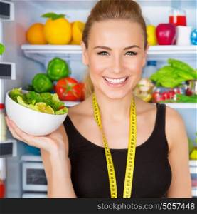 Closeup portrait of beautiful cheerful girl holding in hand bowl with fresh tasty green salad, dietitian recommending eating vegetables, healthy organic nutrition concept