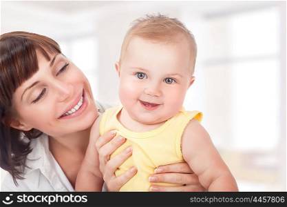 Closeup portrait of beautiful cheerful mother having fun with adorable little daughter at home, happy motherhood concept