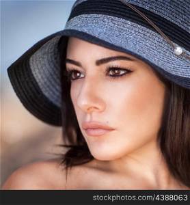 Closeup portrait of beautiful gorgeous woman wearing stylish sun hat, perfect makeup, seriously looking on a side, fashion and beauty