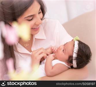 Closeup portrait of beautiful happy mother with cute little daughter on hands, child care, young loving family concept