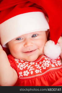 Closeup portrait of beautiful newborn baby wearing red Santa Claus hat, Christmas party, New Year celebration, happiness concept