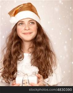 Closeup portrait of beautiful Santa girl holding in hands white gift box, wintertime holidays, Christmas joy, happiness concept